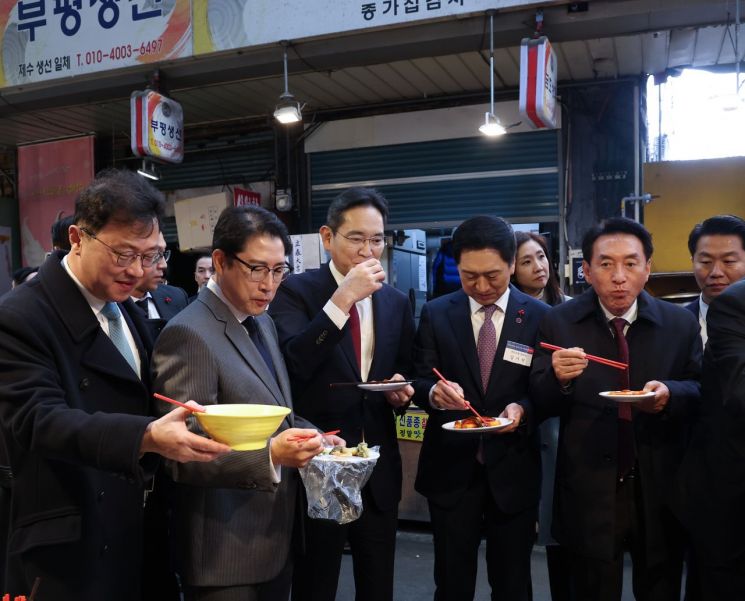 윤석열 대통령과 6일 부산 중구 깡통시장을 함께 찾은 최재원 SK수석부회장(왼쪽부터), 조현준 효성그룹 회장, 이재용 삼성전자 회장, 국민의힘 김기현 대표, 김석기 최고위원이 어묵, 떡볶이 등을 맛보고 있다. [이미지출처=연합뉴스]