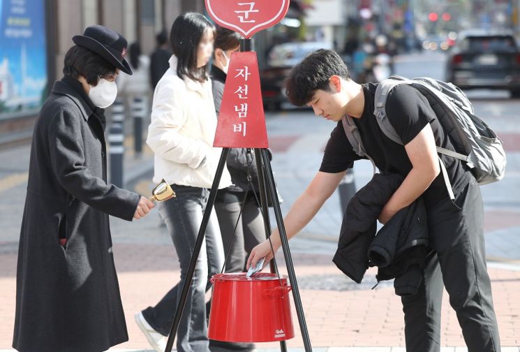 근한 날씨를 보인 8일 대구 중구 동성로에서 가벼운 옷차림을 한 시민이 구세군 자선냄비에 성금을 넣고 있다. 사진=연합뉴스