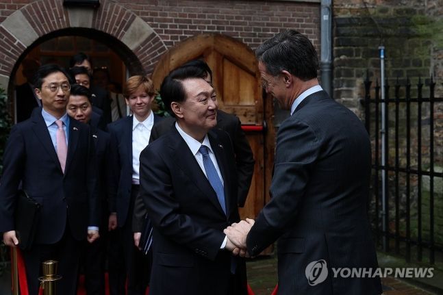 네덜란드를 국빈 방문 중인 윤석열 대통령과 마르크 뤼터 네덜란드 총리가 13일(현지시간) 헤이그의 116년 전 만국평화회의가 열렸던 리더잘(기사의 전당)을 관람한 뒤 악수하고 있다.[사진출처=연합뉴스]
