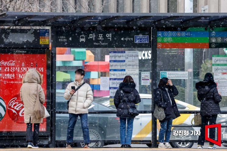 서울 지하철 5호선 마포역 인근에서 시민들이 눈을 맞으며 버스를 기다리고 있다. 사진=강진형 기자aymsdream@