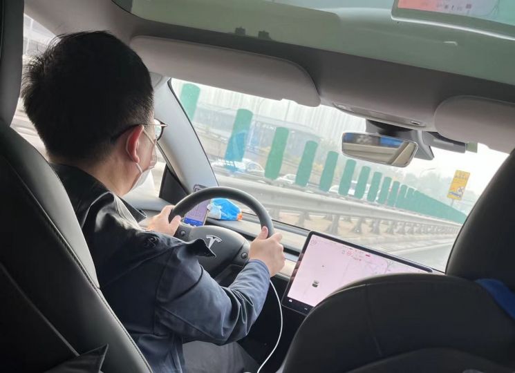 중국에서 생활한 지 얼마 되지 않았던 지난해 10월, 택시를 호출하니 테슬라 차량이 왔다. 이후에도 종종 테슬라를 비롯한 고가의 차량이 배치됐다. 사진은 당시 탑승했던 테슬라 택시와 운전자의 모습. (사진 출처= 김현정 특파원)