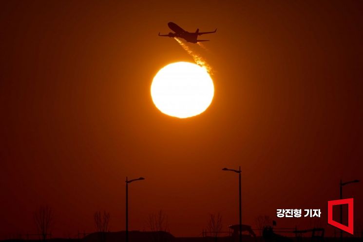 인천국제공항에서 여객기가 붉은 태양과 함께 힘차게 이륙하고 있다. 사진=강진형 기자aymsdream@