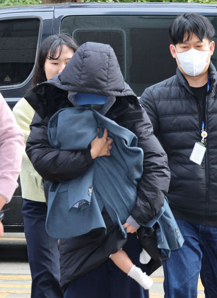 유흥업소 실장과 함께 배우 고 이선균씨를 협박해 금품을 뜯은 혐의를 받는 20대 여성이 아기를 안은 채 지난 28일 인천시 미추홀구 인천지법에서 열린 구속 전 피의자 심문(영장실질심사)에 출석하고 있다. [사진출처=연합뉴스]