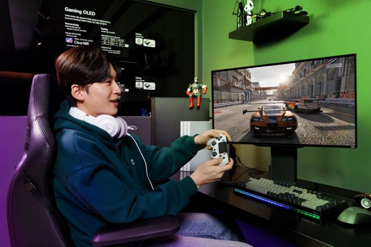LG디스플레이 모델이 '27인치 480㎐ QHD 게이밍 OLED 패널'을 탑재한 모니터로 게임을 즐기고 있다. / [사진제공=LG디스플레이]