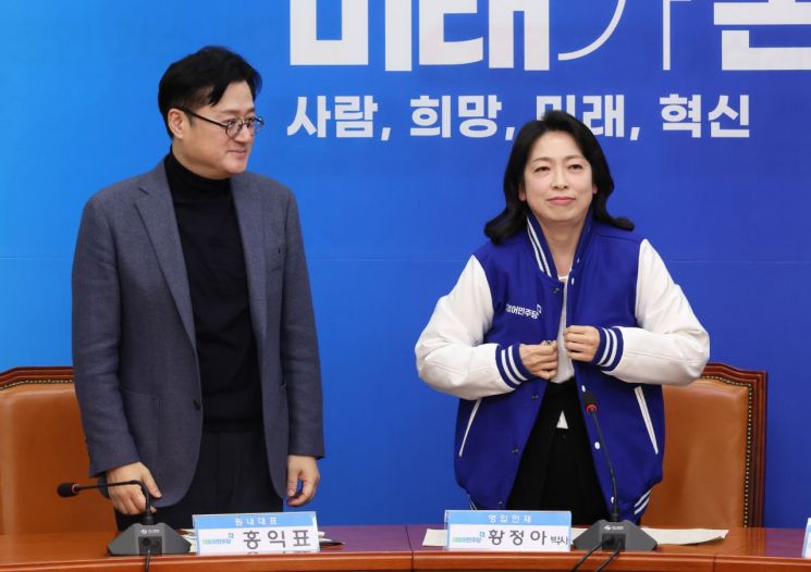 홍익표 더불어민주당 원내대표가 8일 오전 국회에서 열린 영입인재 환영식에서 황정아 한국천문연구원 책임연구원에게 점퍼를 입혀주고 있다. [이미지출처=연합뉴스]