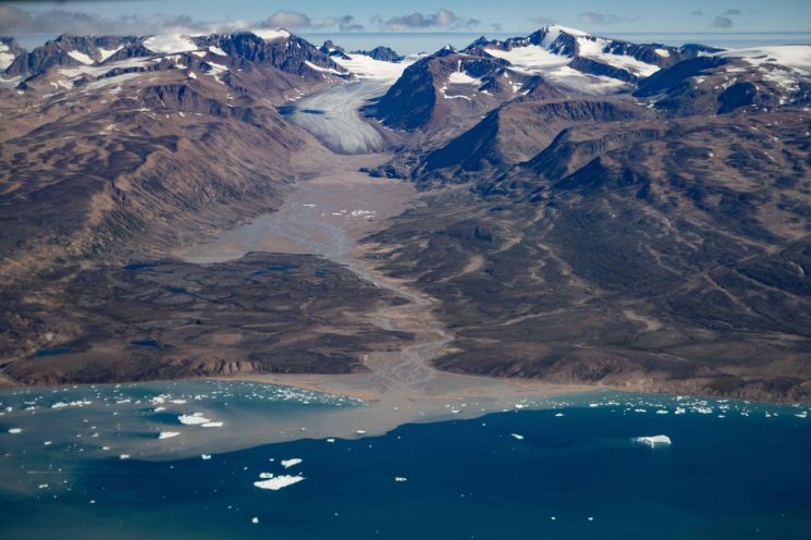 지난해 8월 그린란드 동부의 빙하를 하늘에서 찍은 모습. 눈과 얼음이 녹아 지표면이 드러난 것을 알 수 있다. 북극의 2023년 여름 평균 온도는 6.4도로 1900년 기상 관측 이후 가장 높았다. AFP·연합뉴스