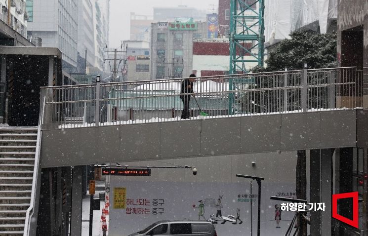 수도권에 많은 눈이 내린 9일 서울 을지로에서 한 건물 관리인이 빗자루로 눈을 쓸고 있다.. 사진=허영한 기자 younghan@