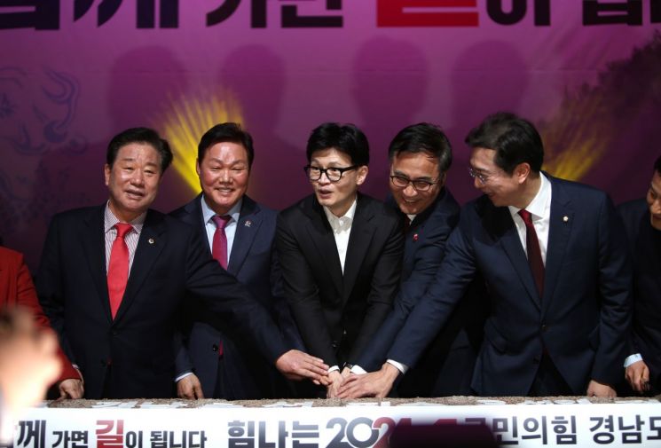 한동훈 국힘 비대위원장(가운데)이 국민의힘 경남도당 신년 인사회에서 떡 케이크를 자르고 있다. [사진=이세령 기자]
