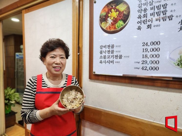 김정옥 갑기회관 대표가 최근 선보인 약용비빔밥을 들고 포즈를 취하고 있다. [사진 = 김희윤 기자]