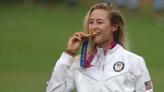 넬리 코다가 도쿄 올림픽 시상대에서 금메달을 깨물고 있다.