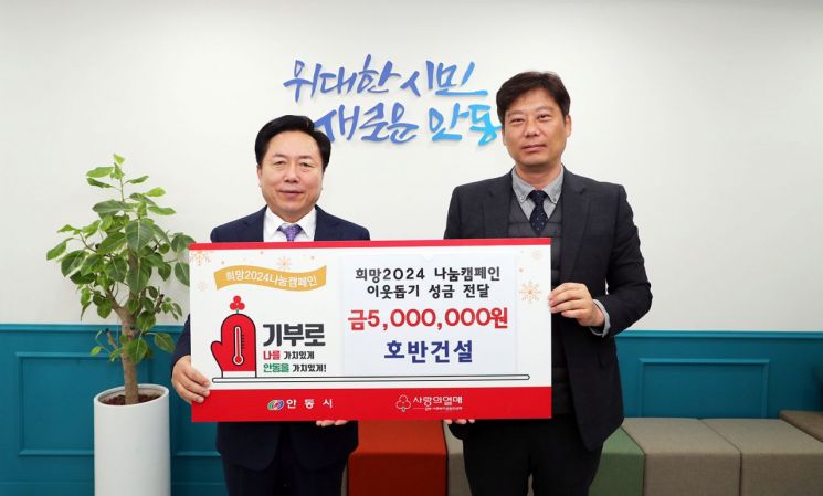 호반건설 박인남 현장소장(오른쪽)이 이웃돕기 성금 500만원을 전달한 뒤 권기창 안동시장과 기념촬영을 하고 있다.