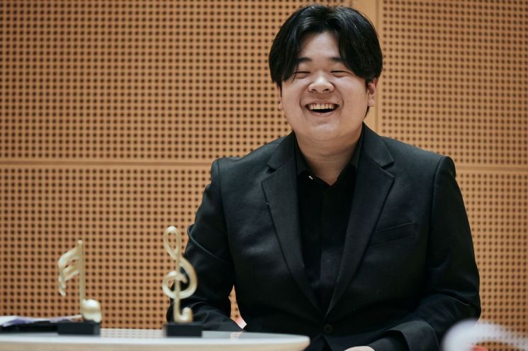 첼리스트 한재민이 19일 롯데콘서트홀에 열린 기자간담회에서 환하게 웃고 있다.   [사진 제공= 롯데문화재단]