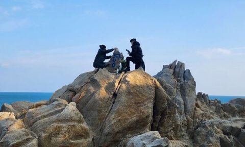 울산 대왕암공원 내 바위에서 발견된 '바다남' 낙서를 지우고 있는 울산 동구청 직원들. [사진=울산 동구 제공]