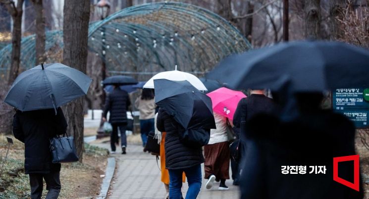 입춘이 지난 뒤 약한 봄비가 내리고 있는 5일 서울 여의도공원에서 시민들이 우산을 쓰고 이동하고 있다. 사진=강진형 기자aymsdream@