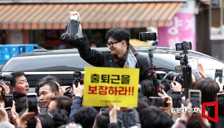 한동훈 국민의힘 비상대책위원장이 설 연휴를 나흘 앞둔 5일 서울 동대문구 청량리 청과물시장·경동시장을 방문해 구매한 상품을 들어보이며 시민들과 인사를 나누고 있다. 사진=김현민 기자 kimhyun81@