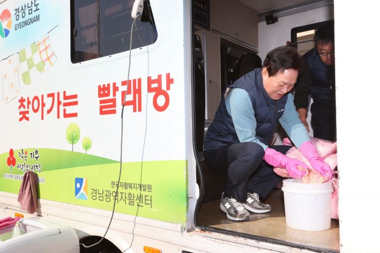 박완수 경남도지사가 ‘찾아가는 빨래방’ 서비스 차량에서 이불 애벌빨래를 하고 있다. [사진제공=경남도청]