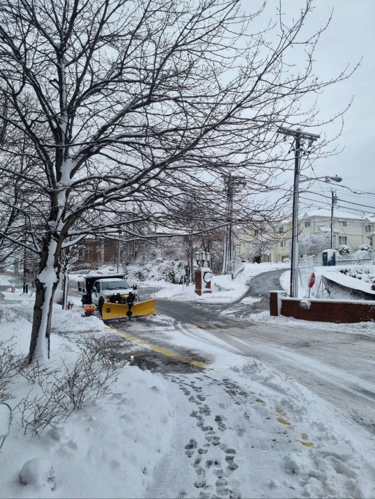 13日 当地时间 纽约附近新泽西一条被大雪覆盖的街道上 除雪车正在清理积雪 纽约=权海英 特派员供图