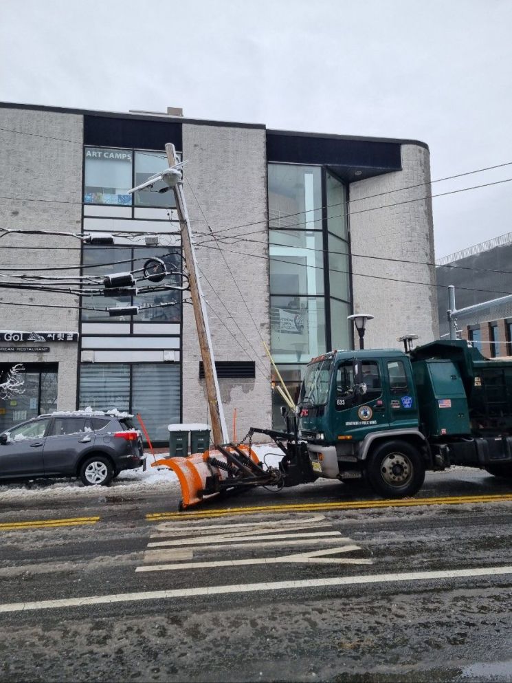 受当地时间13日暴雪和强风伴随的冬季风暴影响，新泽西一处道路上的电线杆发生倾斜。纽约=权海英 特派员供图