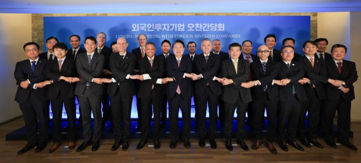 윤석열 대통령이 14일 서울 중구 대한상공회의소 챔버라운지에서 외국인 투자기업 대표들과 연 오찬 간담회를 마치며 참석자들과 손을 잡고 기념촬영을 하고 있다. [이미지출처=연합뉴스]