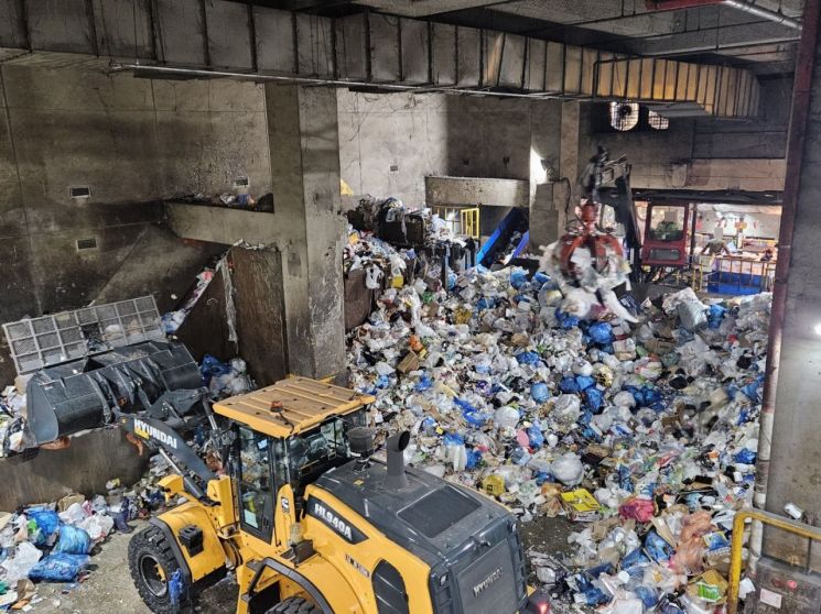 16일 강북재활용품선별처리시설에서 지프크레인이 명절 이후 몰려든 재활용 쓰레기를 옮기고 있다.[사진=이지은 기자]