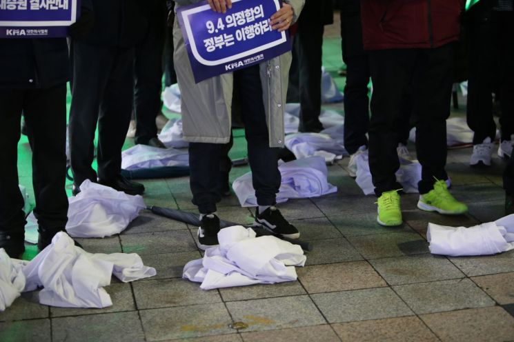 경남의사회가 정부의 의대 증원 정책에 반발하는 의미를 담아 입고 있던 의사 가운을 벗어 바닥에 내려놨다. [사진=이세령 기자]