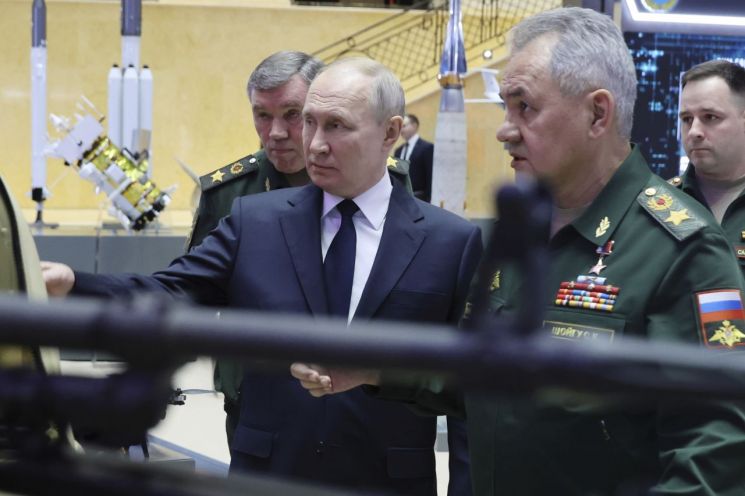 블라디미르 푸틴 러시아 대통령(가운데)이 지난해 12월 모스크바에서 세르게이 쇼이구 국방장관(오른쪽)과 함께 국방부 이사회 확대회의에 참석한 뒤 군사 전시회를 둘러보고 있다. [사진=모스크바 AP/연합뉴스]