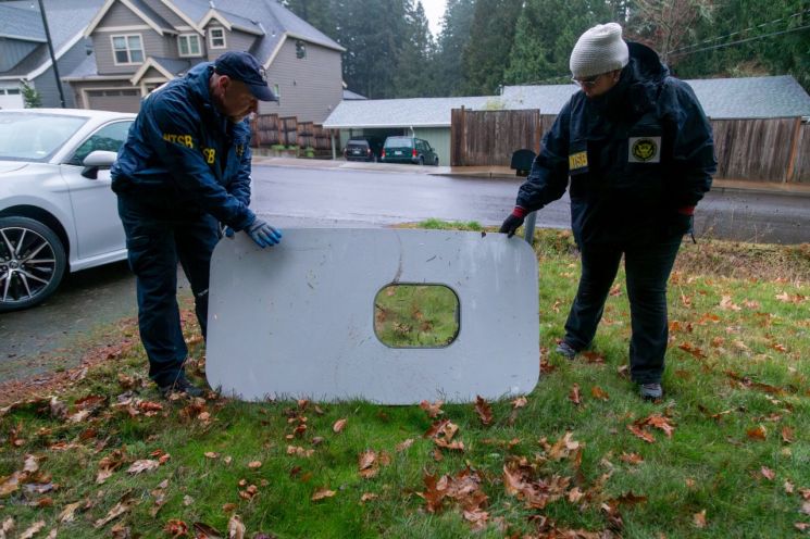 지난 1월8일(현지시간) 미국 국가교통안전위원회(NTSB) 조사관들이 오리건주 포틀랜드 주택가에서 발견된 알래스카 항공 1282편 보잉 737 맥스 9의 도어 플러그를 살펴보고 있다. [사진출처=로이터 연합뉴스]