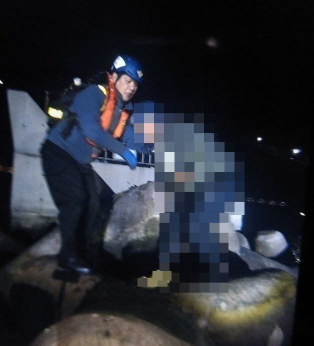 昌原海警正在将被困在消波块下方的求助者拉上来。 昌原海洋警察署供图