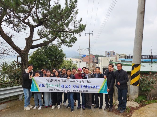 신지면 울모래 마을 주민들이 전남에서 살아보기 첫 개소를 환영하고 있다. [사진제공=완도군]