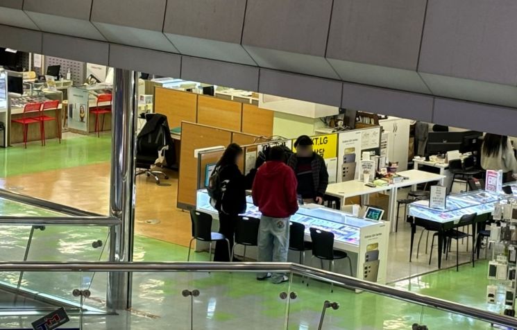 6일 서울 강변 테크노마트에서 판매점 관계자가 휴대폰을 구매하러 온 고객을 상담하고 있다/사진=황서율 기자chestnut@