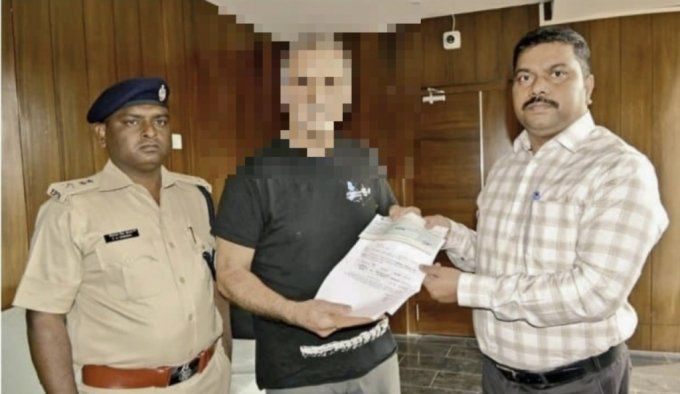인도 여행을 하다 집단 성폭행을 당한 아내의 남편이자 폭행 피해자에게 위로금인 10라크 수표를 전달하면서 기념사진을 찍은 인도 경찰. [이미지출처=인디아투데이 캡처]