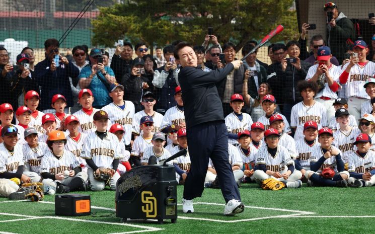 윤석열 대통령이 16일 서울 용산어린이정원 야구장에서 열린 샌디에이고 파드리스의 어린이 야구교실에서 유소년 야구선수들이 지켜보는 가운데 직접 타격해 보고 있다. [이미지출처=연합뉴스]