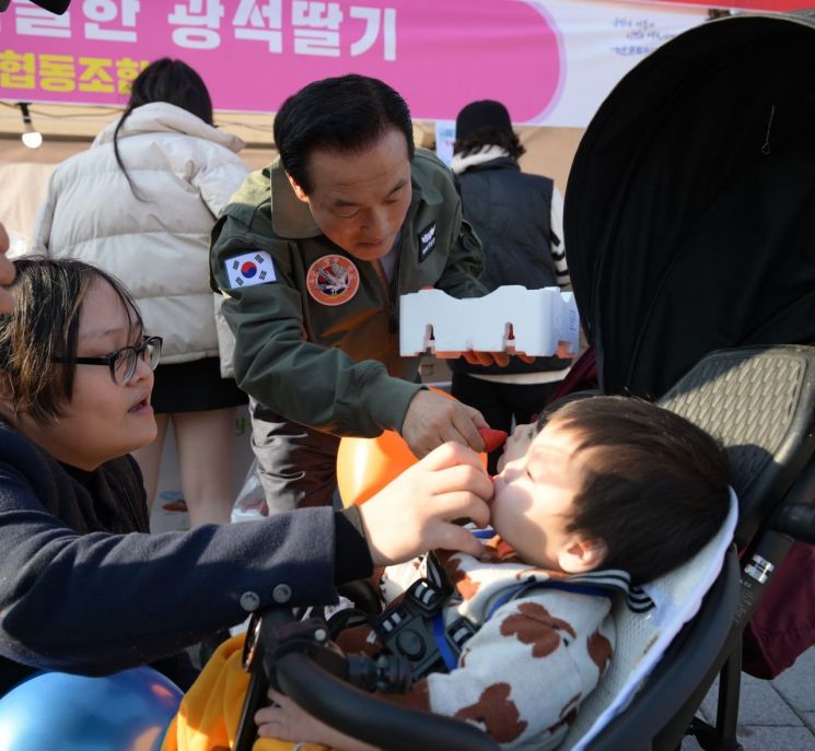 백성현 논산시장이 부모와 함께 딸기 축제장을 찾은 아이에게 딸기 먹여주고 있다./논산시청