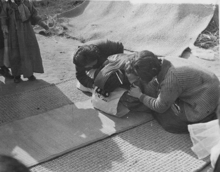 1960年代，庆尚北道醴泉郡殷丰面果山谷村的一场婚礼上，戴着族头里的新娘在他人搀扶下行礼的情景格外引人注目。