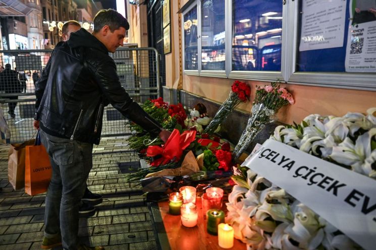 23일(현지시간) 러시아에서 총기 난사 및 방화 테러가 발생한 뒤 한 시민이 사건 현장에서 꽃을 놓고 있는 모습 [이미지출처=AFP연합뉴스]