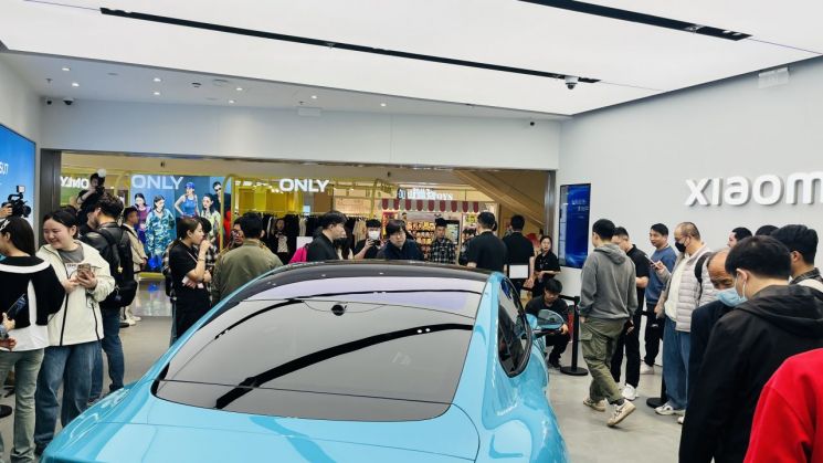 25일 오전 중국 베이징 차오양구 허셩후이 쇼핑센터 내 샤오미 매장에 방문객들이 차량을 살펴보고 있다. (사진 출처= 김현정 특파원)