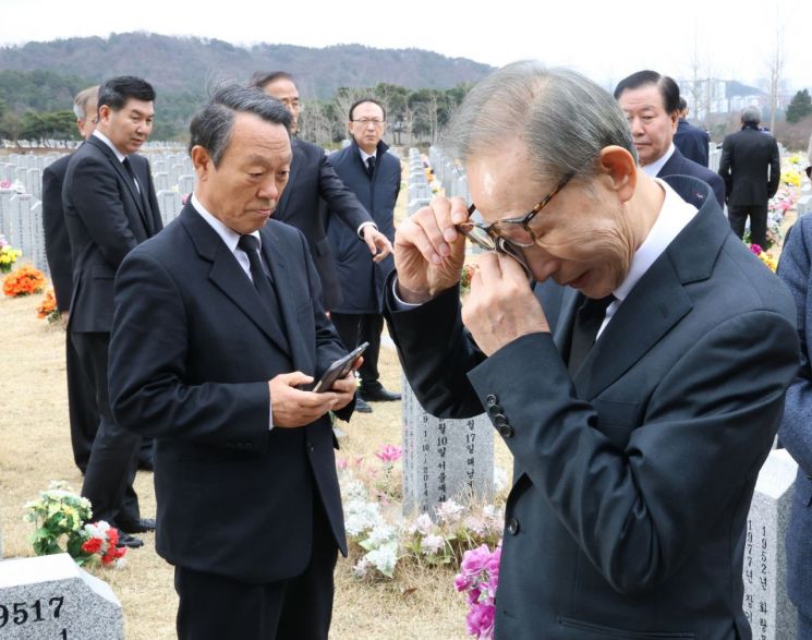 이명박 전 대통령이 25일 오전 국립대전현충원 천안함 46용사 묘역을 찾아 참배 후 묘비 주변을 확인하다 눈가를 닦고 있다. [이미지출처=연합뉴스]