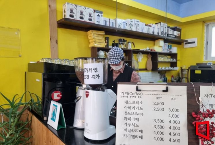 서울 성북구 대학가의 개인 카페 사장이 커피를 내리고 있다. 메뉴판에 아이스 아메리카노 한 잔에 3000원이라고 써있다.[사진=심성아 기자]