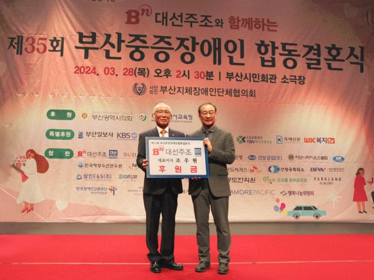 대선주조 차재영 상무(오른쪽)가 부산지체장애인단체협의회 유영호 회장에게 후원금을 전하고 있다.