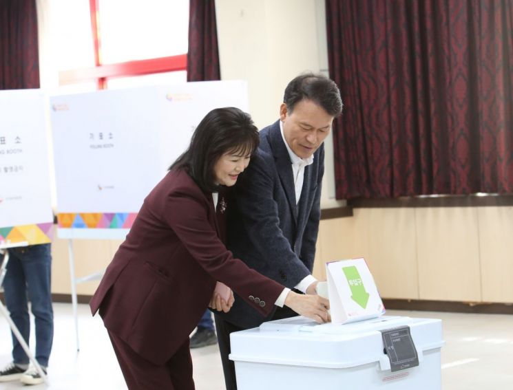 국민의힘 윤한홍 경남 창원시 마산회원구 국회의원 후보가 배우자와 함께 기표한 사전투표용지를 투표함에 넣고 있다. [사진=이세령 기자]