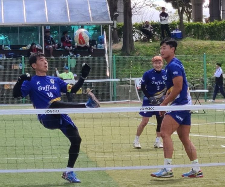 아버지(왼쪽)와 아들이 한팀으로 족구대회에 출전해 경기를 뛰고 있다.