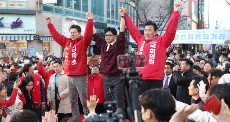 한동훈 국민의힘 비상대책위원장(가운데)이 26일 오후 경남 양산시 양산남부시장을 찾아 같은 당 윤영석(오른쪽)·김태호 후보 지지를 호소하고 있다. [사진출처=연합뉴스]