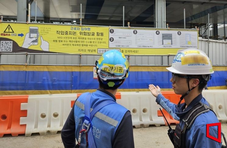 경기도에 위치한 한 삼성물산 건축현장에서 근로자들이 작업중지권 현수막을 확인하고 있다.(사진제공=삼성물산)