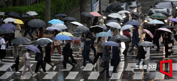 봄비가 내리고 있는 15일 서울 종로구 광화문 인근에서 시민들이 우산을 쓰고 이동하고 있다. 사진=조용준 기자 jun21@
