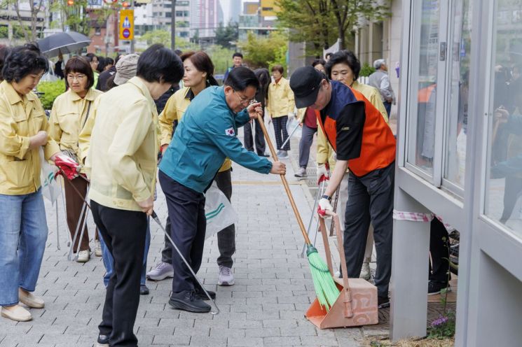 박강수 마포구청장이 용강동 대청소날 행사에 참석해 거리 청소하는 모습