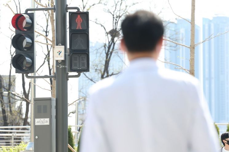 지난 9일 오전 서울 시내 한 대형병원에서 한 의료 관계자가 횡단보도 신호를 기다리고 있다. [이미지출처=연합뉴스]