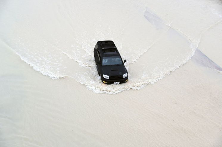 16일(현지시간) 두바이에서 폭우가 내리는 가운데 운전자가 차를 운전하고 있다. [이미지출처=EPA연합뉴스]