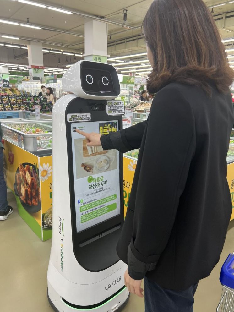 서울 양재 하나로마트를 방문한 고객이 ‘안내 로봇’을 터치해 풀무원 제품 정보를 확인하고 있다.[사진제공=풀무원]