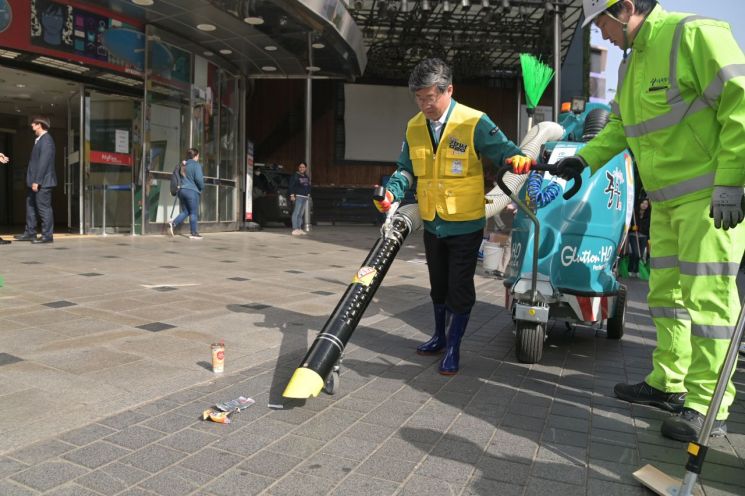 김길성 중구청장이 명동 거리를 진공청소기로 거리 청소하고 있다.