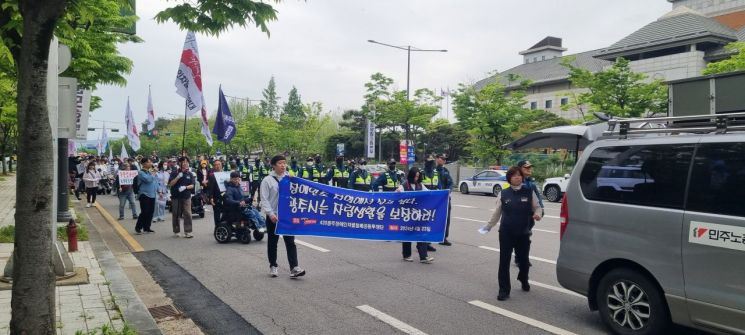 23일 오후 광주광역시 서구 김대중컨벤션센터 주변에서 지역 장애인 단체 관계자들이 행정당국을 향해 장애인 정책 마련을 촉구하며 거리행진을 하고 있다[사진=민현기 기자]